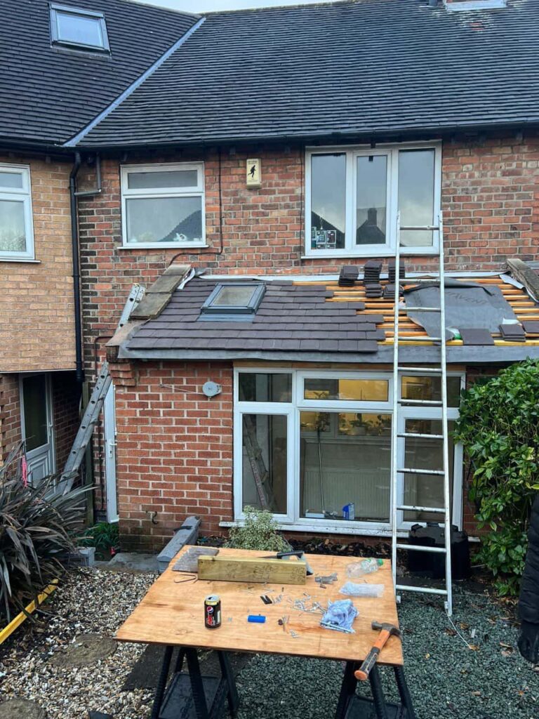 This is a photo of a roof extension that is having new roof tiles installed. This is a photo taken from the roof ridge looking down a tiled pitched roof on to a flat roof. Works carried out by Littleport Roofing Repairs