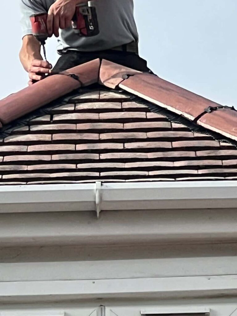 This is a photo of one of the operatives of Littleport Roofing Repairs installing new ridge tiles