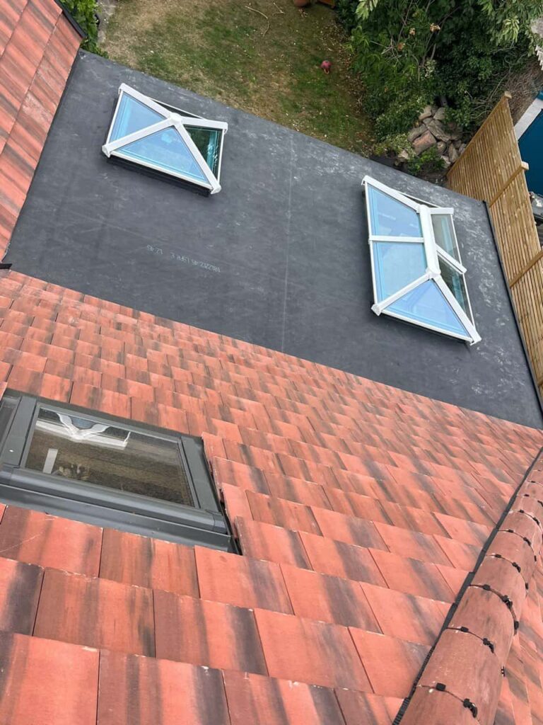 This is a photo taken from the roof ridge looking down a tiled pitched roof on to a flat roof. Works carried out by Littleport Roofing Repairs